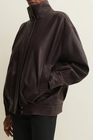 side profile model wearing zipped Paula Vegetal Leather Jacket coffee bean brown Oversized jacket
High collar
hidden zipper closure
Relaxed yet structured silhouette
100% Sheep Leather