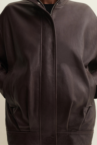 front profile model closeup wearing zipped Paula Vegetal Leather Jacket coffee bean brown Oversized jacket
High collar
hidden zipper closure
Relaxed yet structured silhouette
100% Sheep Leather