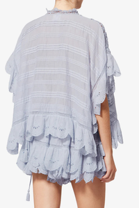 back profile model wearing Payton Top Light Blue Caftan style organic cotton and floral lace top
Round collar with tie strings
Broderie anglaise and pintucks
Short frilly sleeves
Side frills and drawstrings
Flared cut
100% cotton