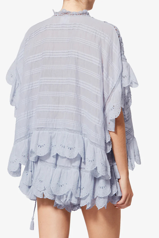 back profile model wearing Payton Top Light Blue Caftan style organic cotton and floral lace top
Round collar with tie strings
Broderie anglaise and pintucks
Short frilly sleeves
Side frills and drawstrings
Flared cut
100% cotton