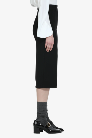 side profile model wearing Pencil Skirt black calf length Center seams at the front and back
Belt loops