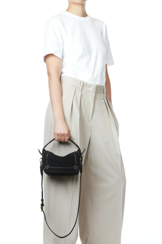 side profile model wearing bag on hand Pepito S Noir suede Bag Shoulder bag, 
Quilted leather handle
Long adjustable, removable strap 
Zippered exterior pocket at the back of the bag
80% Calfskin 20% Goatskin / Lining 100% Cotton