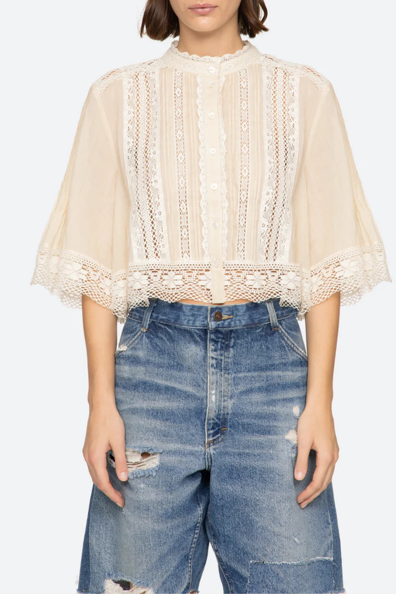 front profile model wearing Pippa Solid Short Sleeve Top Short sleeve
Softly raised neckline
Delicate pleating
Lace inserts throughout
Cropped silhouette
Floral lace hem
Airy, flowing sleeves
100% cotton
Button front
