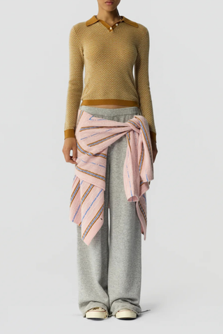 front profile model wearing  Pique Shrunken Long Sleeve Polo Cashmere suede caramel FINE WEIGHT LS PIQUE STITCH POLO
RIB POLO COLLAR
THREE BUTTON HALF PLACKET CLOSURE
RIB HEM AND CUFF TRIM
FINE TWO COLOR TEXTURE PIQUE STITCH
GIR BRANDING AT BACK NECK