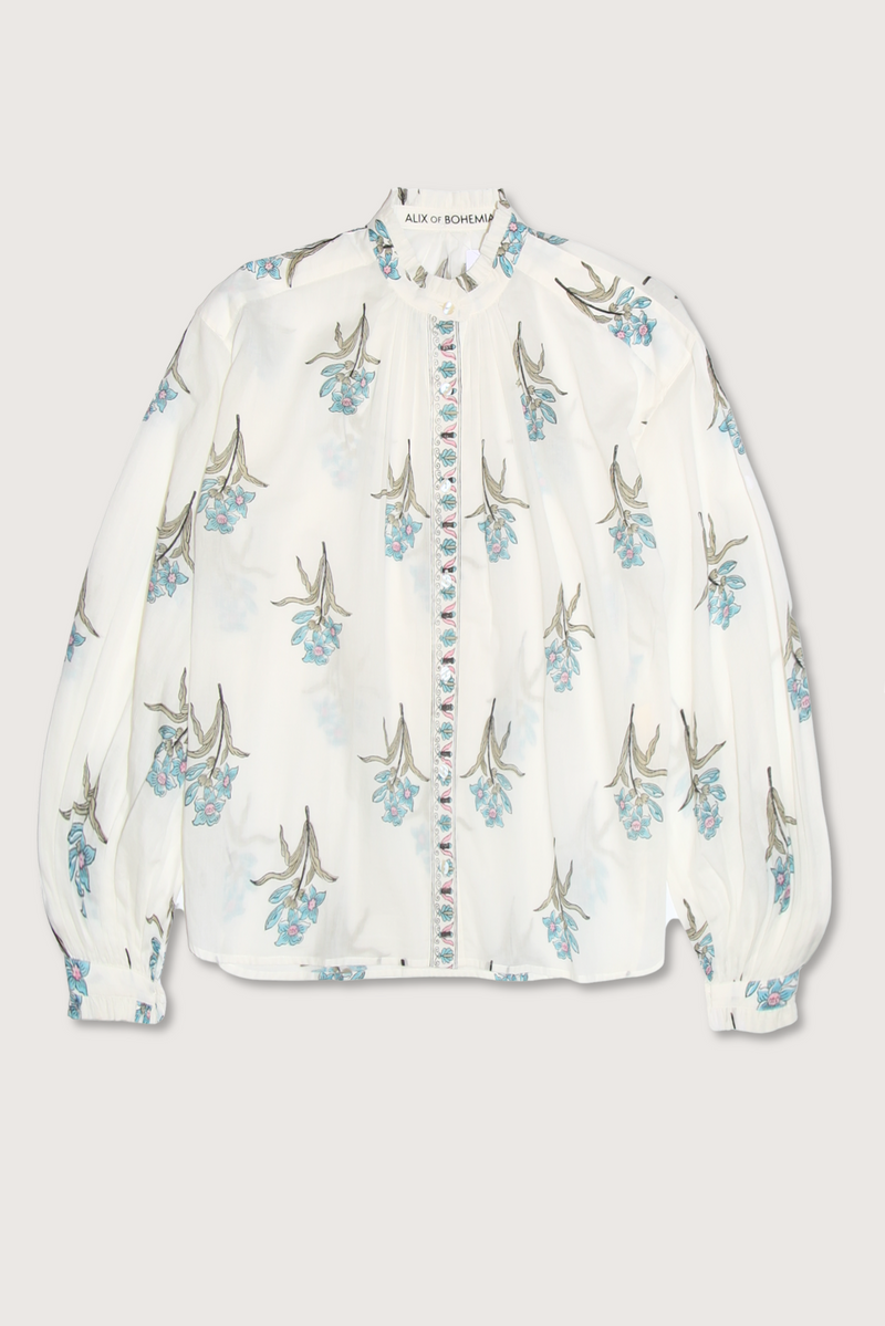 flat lay Poet Sky Mist Flower Blouse off white cotton Loose fit
Ruffled collar
Dramatically gathered sleeves
Slightly sheer
Hand-block-printed with signature falling floral motif
Border-print placket
Block-printed by hand