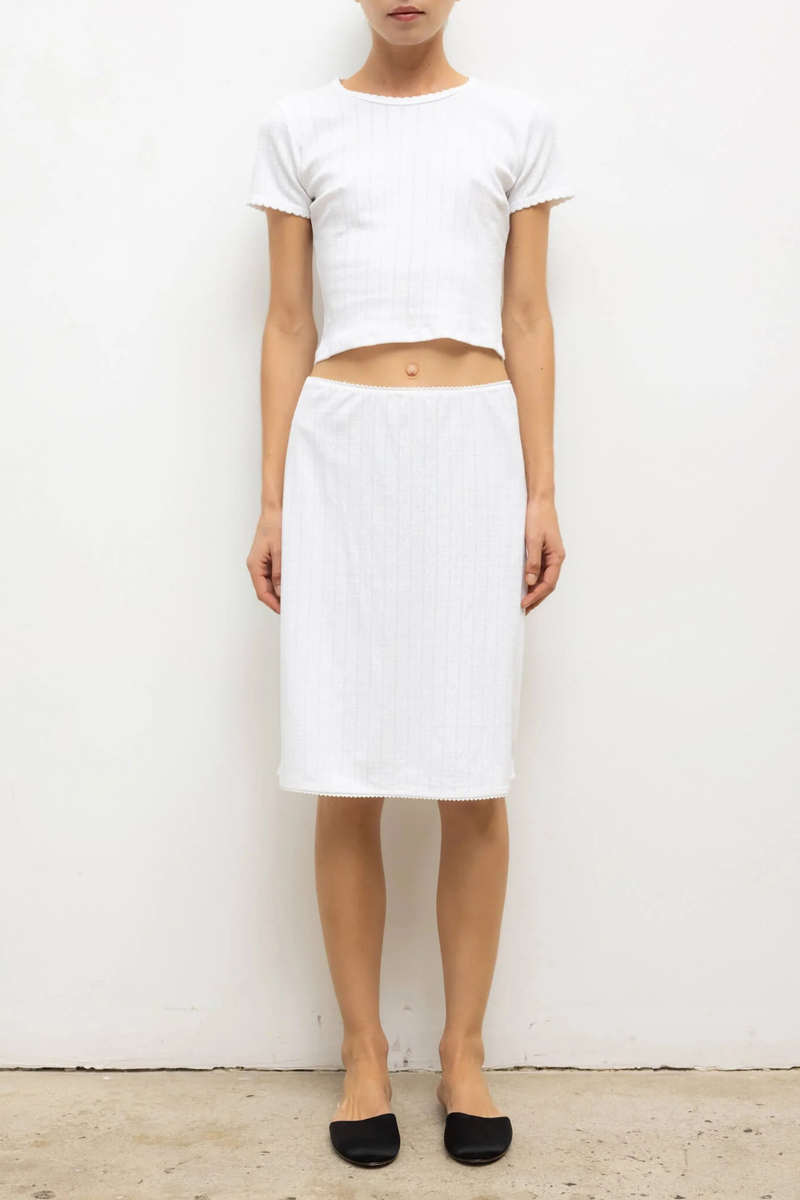 front profile model wearing Pointelle Baby Tee White slim fit
Cropped length
Cap-style sleeve
Classic crew neckline
Signature pinhole stripes
Delicate eyelets
Scalloped edging
100% Cotton