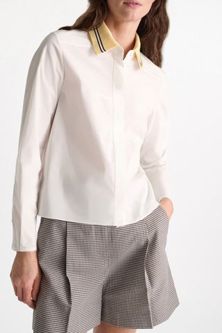 front profile model wearing Poplin Power Blouse white with Lemon Knit white Contrast color striping
96 % Cotton, 4 % Elastane
A-line cotton poplin shirt with removable collar
Knit polo collar
Raw finish cuffs