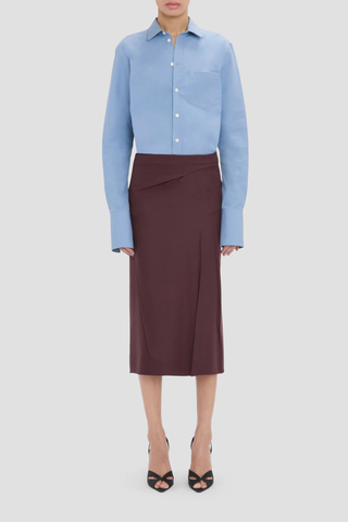 front profile model wearing  Pressed Tailored Flannel Skirt Acai (Merlot) Pressed Tailored Skirt
Compact flannel
Fabric is pressed for a sharp, structured finish
Fit & flare shape
Mid rise and midi length
Exposed seam detailing
100% Virgin Wool