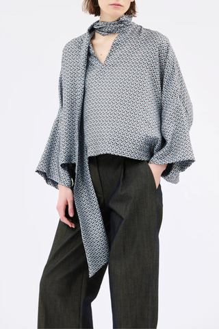 front profile model wearing Printed Silk Neck Tie Blouse foggy blue Bow-tie blouse
Soft, flowing cut
Wide, dropped sleeves
V-neck with decorative stitching
100% silk