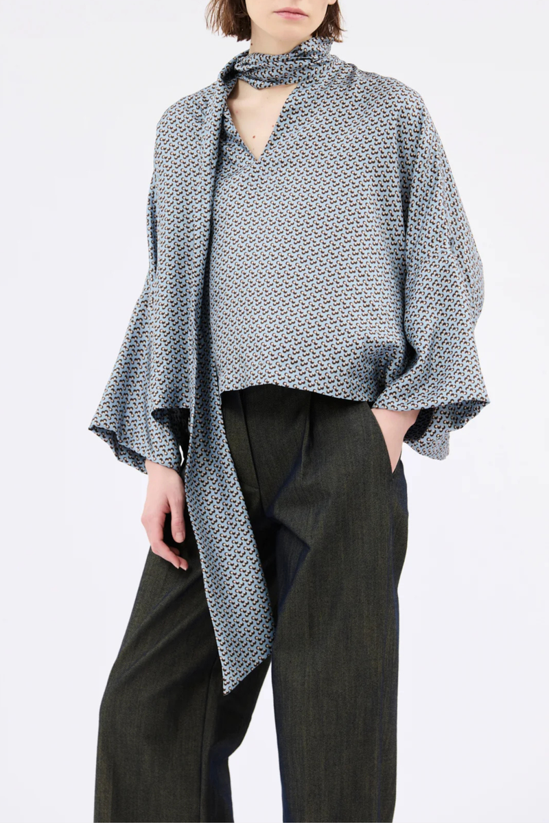 front profile model wearing Printed Silk Neck Tie Blouse foggy blue Bow-tie blouse
Soft, flowing cut
Wide, dropped sleeves
V-neck with decorative stitching
100% silk