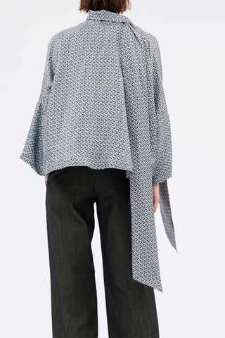 back profile model wearing Printed Silk Neck Tie Blouse foggy blue Bow-tie blouse
Soft, flowing cut
Wide, dropped sleeves
V-neck with decorative stitching
100% silk
