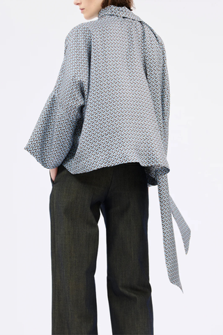 side profile model wearing Printed Silk Neck Tie Blouse foggy blue Bow-tie blouse
Soft, flowing cut
Wide, dropped sleeves
V-neck with decorative stitching
100% silk