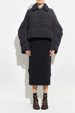 front profile model wearing Puffer Coat Black cropped fit Wide sleeves that taper gently at the cuff, elastic drawcord hem
