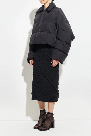 side profile model wearing Puffer Coat Black cropped fit Wide sleeves that taper gently at the cuff, elastic drawcord hem