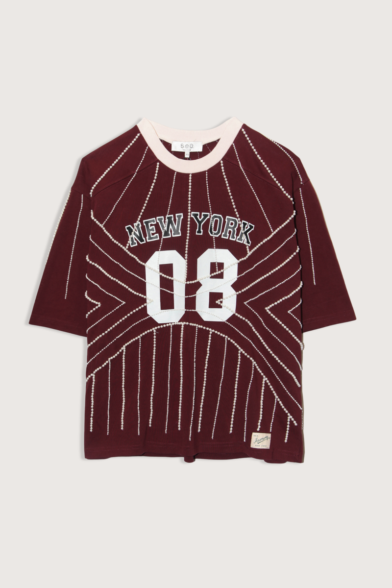 flat lay Quinn T-Shirt burgundy Beaded t-shirt
Inspiration from classic sports jerseys
Varsity-style lettering and numerals
Contrast trim at the collar
Intricate pearl beading throughout
Each piece is hand beaded
Slight variations in bead placement, spacing, and natural drape may occur
100% cotton
Relaxed fit