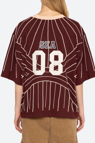 back profile model wearing Quinn T-Shirt burgundy Beaded t-shirt
Inspiration from classic sports jerseys
Varsity-style lettering and numerals
Contrast trim at the collar
Intricate pearl beading throughout
Each piece is hand beaded
Slight variations in bead placement, spacing, and natural drape may occur
100% cotton
Relaxed fit