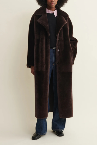 front profile model wearing shearling side of Rein Nappa Reversible Shearling coffee bean dark brown waist tie belt included
Reversible for two distinct looks: shearling side and leather side
Regular fit
100% Lamb Leather
unlined
long length