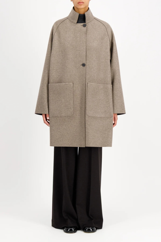 front profile model wearing Reversible Cape With Loro Piana taupe and brown Raglan cape
Unlined
Reversible cape
Long sleeve
2 button fastening
Stand-up collar
Big patch pocket on both internal and external layer
Single layer in double colour wool
Raw-edge finish