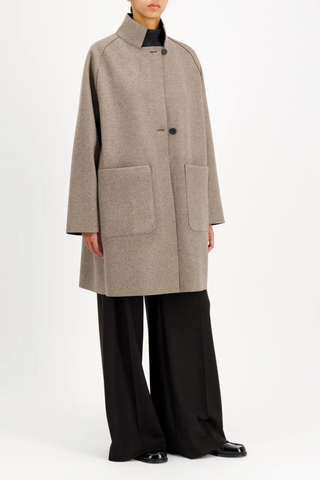 side profile model wearing Reversible Cape With Loro Piana taupe and brown Raglan cape
Unlined
Reversible cape
Long sleeve
2 button fastening
Stand-up collar
Big patch pocket on both internal and external layer
Single layer in double colour wool
Raw-edge finish
