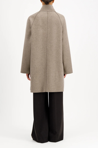 back profile model wearing Reversible Cape With Loro Piana taupe and brown Raglan cape
Unlined
Reversible cape
Long sleeve
2 button fastening
Stand-up collar
Big patch pocket on both internal and external layer
Single layer in double colour wool
Raw-edge finish