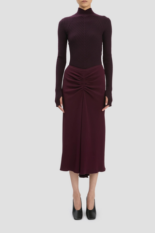 front profile model wearing Ribbed Long Sleeve with thumb holes Knit Polo Merlot high v-neckline merino wool curved v hemline