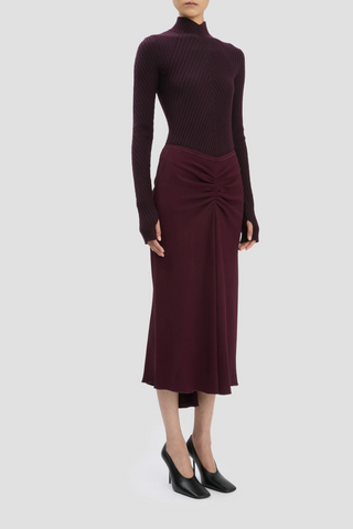 side profile model wearing Ribbed Long Sleeve with thumb holes Knit Polo Merlot high v-neckline merino wool curved v hemline