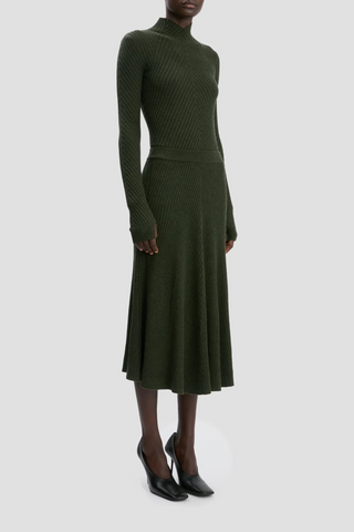 side profile model wearing Ribbed Long Sleeve with thumb holes Knit Polo Oregano high neck with v-neckline merino wool curved v hemline