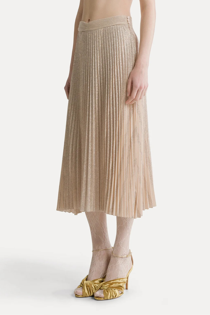 front profile model wearing Rinsing Sun Soleile Plisse Skirt loto Below–the–knee length
Delicate interplay of light and shadow in lamé and sunray plissé
Flared at the hem
Fastened at the side with retro–inspired covered buttons
High-waisted skirt
Zip and button closure
Loose fit
Wide bottom
