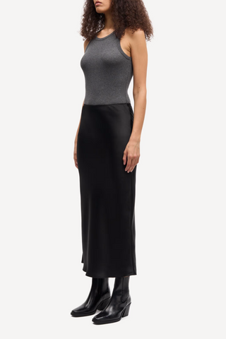 side profile model wearing Saagneta Long Satin Skirt Black slim fit elastic waist
