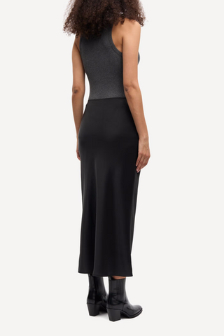 back profile model wearing Saagneta Long Satin Skirt Black slim fit elastic waist
