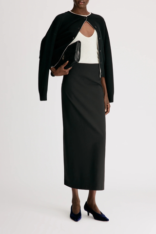 front profile model wearing  Samos Fitted Straight Maxi Skirt Virgin Wool/Elastane black Virgin wool grain de poudre
Maxi length pencil skirt
Side zipper fastening
Back vent
95% VIRGIN WOOL 5% ELASTANE