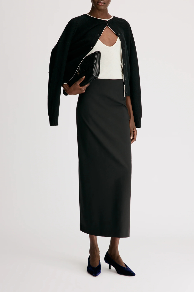 front profile model wearing  Samos Fitted Straight Maxi Skirt Virgin Wool/Elastane black Virgin wool grain de poudre
Maxi length pencil skirt
Side zipper fastening
Back vent
95% VIRGIN WOOL 5% ELASTANE