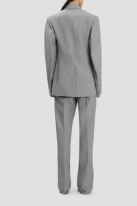 back profile model wearing Sculptural Sleeve Jacket light grey virgin wool oversized fit 3-hole button on cuff with contrast white stitch detail