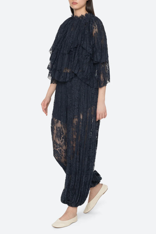 side profile model wearing Sharleen Lace Cape Top navy Cape-style silhouette
Intricate floral lace
Subtle pleated detailing
Slightly cropped length
Asymmetrical hem
self-51% cotton, 49% polyester with matching balloon pants navy