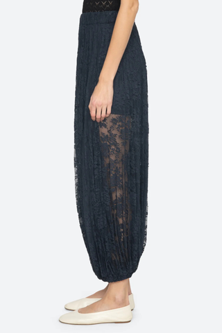 side profile model wearing Sharleen Lace Pant Navy Voluminous balloon silhouette
Pleated elasticized waistband
Sheer floral lace
Self-51% cotton, 49% polyester
Slip on

Elasticized waist