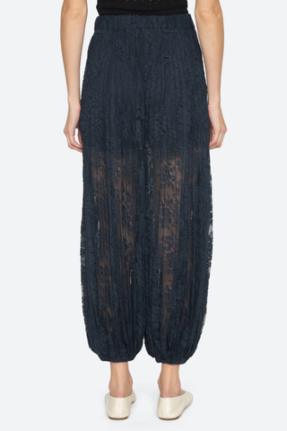 back profile model wearing Sharleen Lace Pant Navy Voluminous balloon silhouette
Pleated elasticized waistband
Sheer floral lace
Self-51% cotton, 49% polyester
Slip on

Elasticized waist