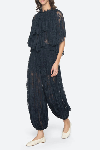 side profile model wearing Sharleen Lace Pant Navy Voluminous balloon silhouette
Pleated elasticized waistband
Sheer floral lace
Self-51% cotton, 49% polyester
Slip on

Elasticized waist with matching top