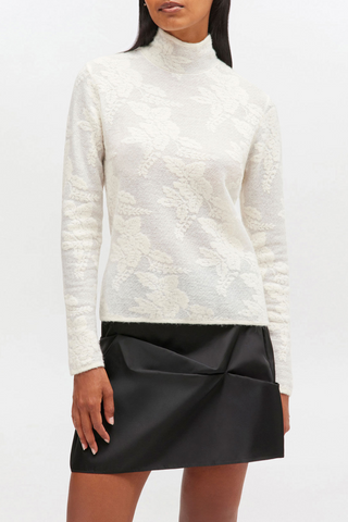 front profile model wearing Sheer Flower Jacquard Mock Neck white sheer flower print long sleeves