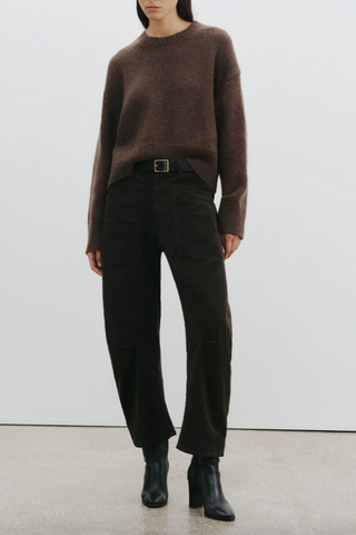 front profile model wearing Shon Corduroy Pant Chocolate brown mid rise barrel leg front utility pockets