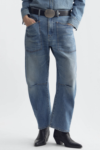front profile model wearing Shon Jeans Cienna Wash mid blue wash Mid-rise
Relaxed fit
Barrel leg jean
Uniquely curved silhouette
Seam detail at knees
Gusset at inseam
Zip fly
Shank closure
Top-stitched front and back patch pockets
Belt loops
100% Cotton