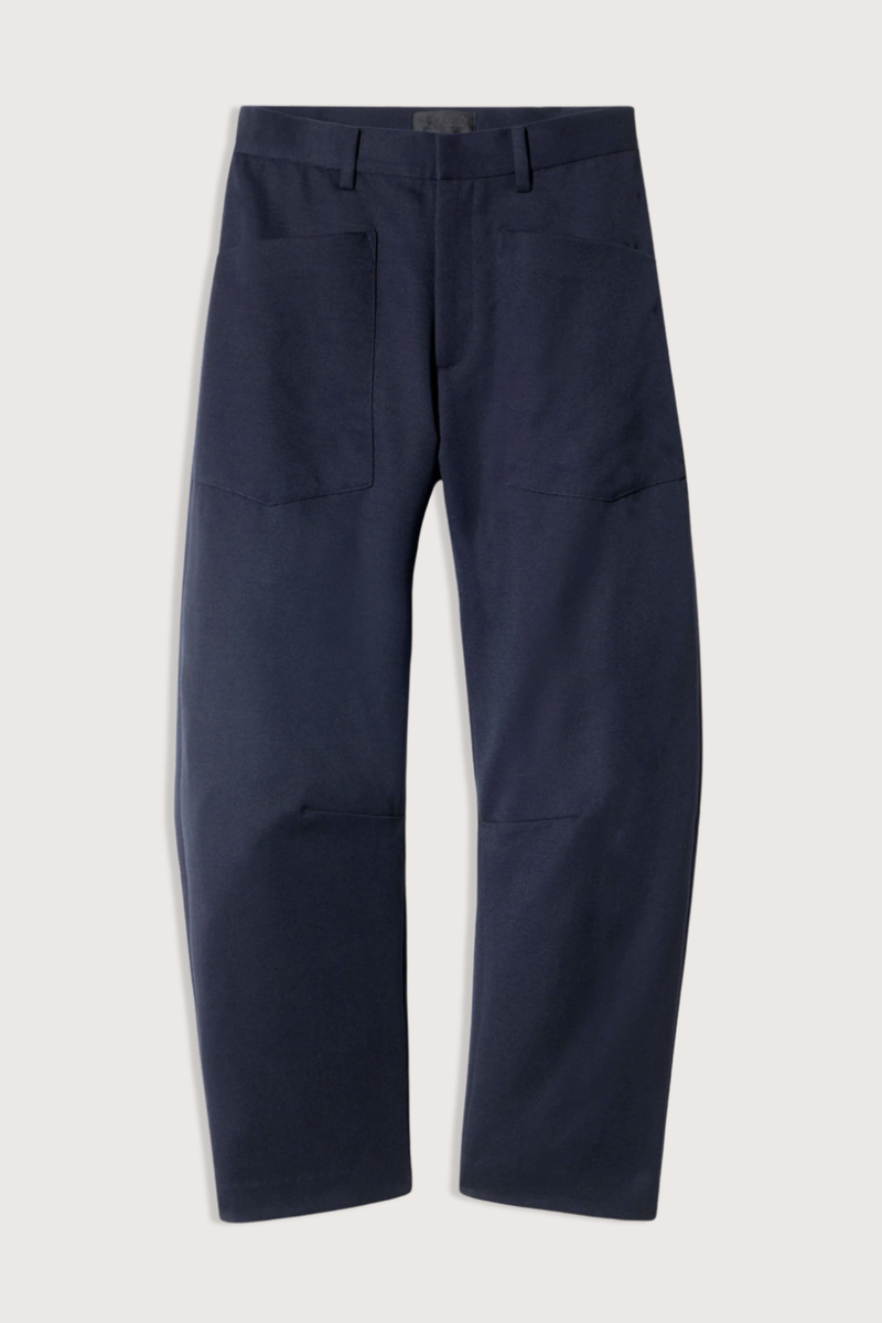 flat lay Shon Wool Gaberdine Pant Midnight navy wool Mid-rise
Relaxed fit barrel leg pant
Uniquely curved silhouette
Seam detail at knees
Gusset at inseam