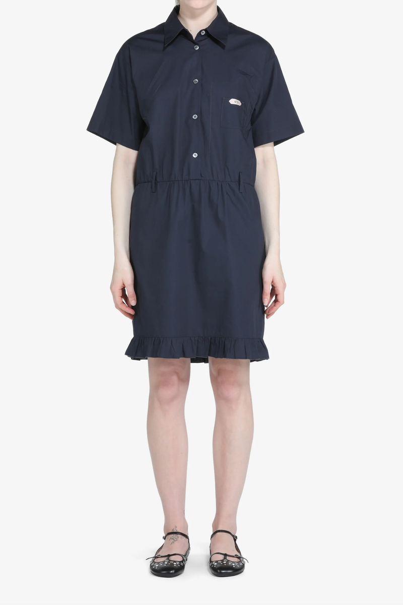 front profile model wearing Short Sleeve Poplin Dress Blue navy cotton Navy blue shirt dress
Classic collar
Short sleeves
Button-up front
Shirtdress style
Elastic waistband
Hem is finished with a ruffle
Above-the-knee length
