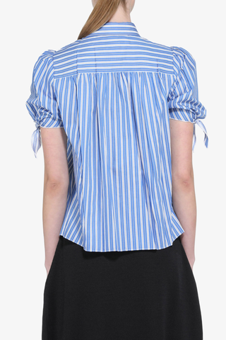 back profile model wearing Short Sleeve Striped Top blue white stripe cotton Short sleeve
Classic collar
Blue and white pattern runs throughout the garment
Front closure features large jewel buttons
Puffed sleeves close with a tied ribbon