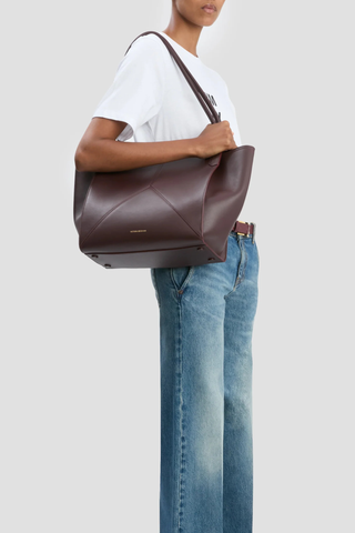 model wearing Small Victoria Soft Calf Leather Tote burgundy Tonal suede lining
Unstructured silhouette
Minimal hardware
Discreetly decorative V-stitched panels