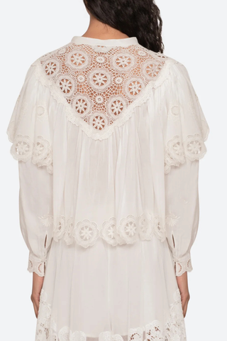 back profile model wearing Embroidered long sleeve
Long puff sleeves
Scalloped hem
Tie at the neckline
Self-100% cotton
Embroidery-100% polyester
Button front