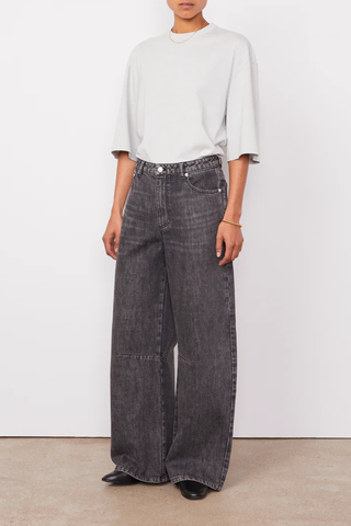 front profile model wearing Sora Denim Anthracite Low-waisted 5 pockets, loose fit
100% Cotton
Curved and wide leg
Darts at knees
Tone on tone topstitching
Silver jeans button and rivets.