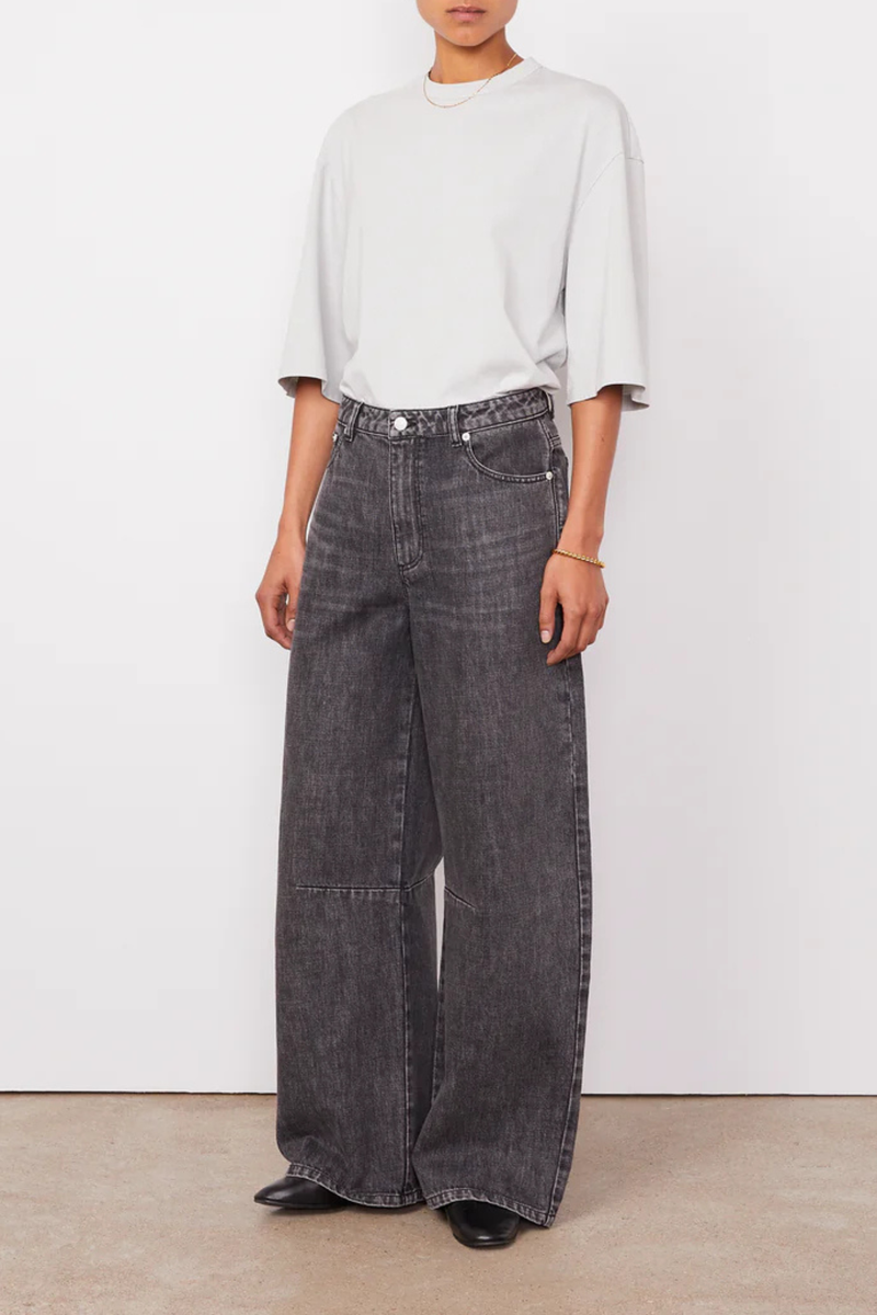 front profile model wearing Sora Denim Anthracite Low-waisted 5 pockets, loose fit
100% Cotton
Curved and wide leg
Darts at knees
Tone on tone topstitching
Silver jeans button and rivets.