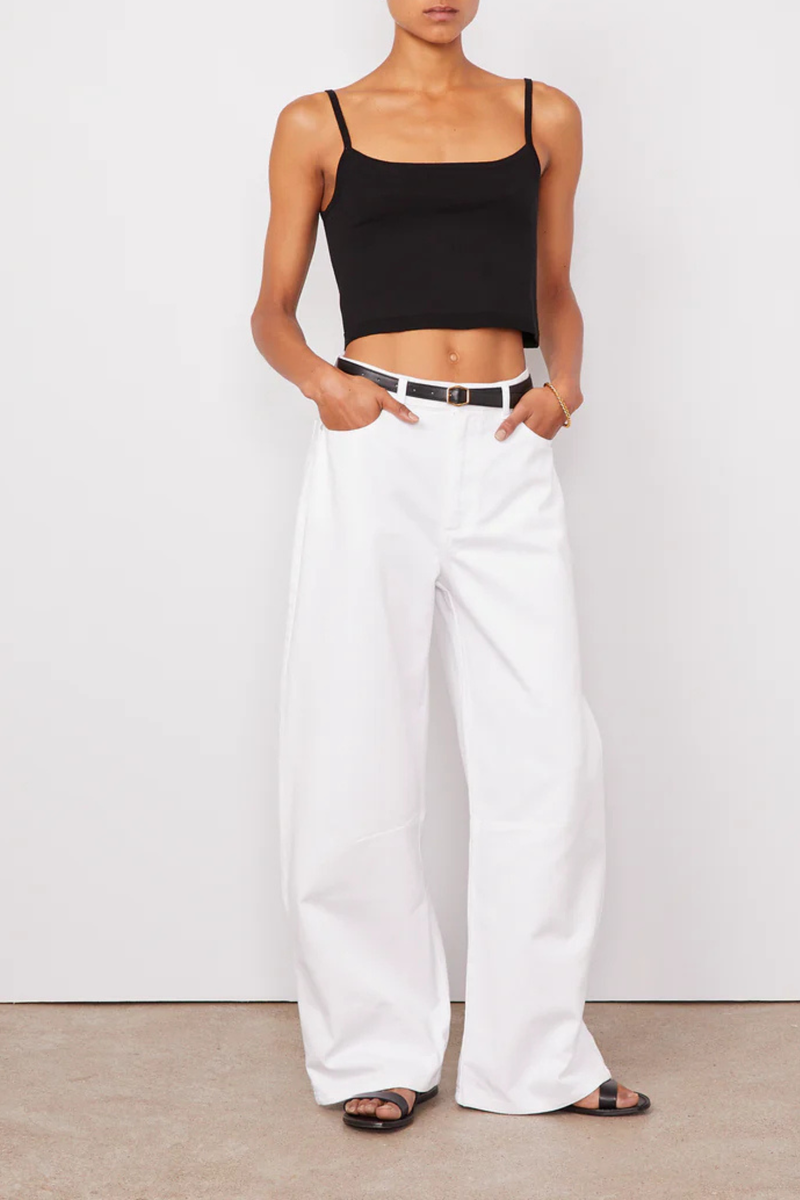 front profile model wearing Sora Denim White Low-waisted 5 pockets, loose fit

100% Oragnic Cotton
Curved and wide leg
Darts at knees
Tone on tone topstitching
Silver jeans button and rivets