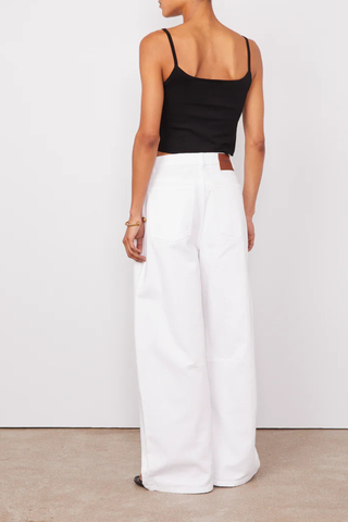 back profile model wearing Sora Denim White Low-waisted 5 pockets, loose fit

100% Oragnic Cotton
Curved and wide leg
Darts at knees
Tone on tone topstitching
Silver jeans button and rivets