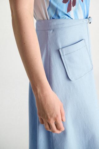 side profile close up model wearing Sporty Chic Cotton Skirt mineral blue 100 % Cotton
Cotton skirt
Belted waist
Center front slit
Faux front button placket
Patch pockets
In-seam side zip closure
Unlined